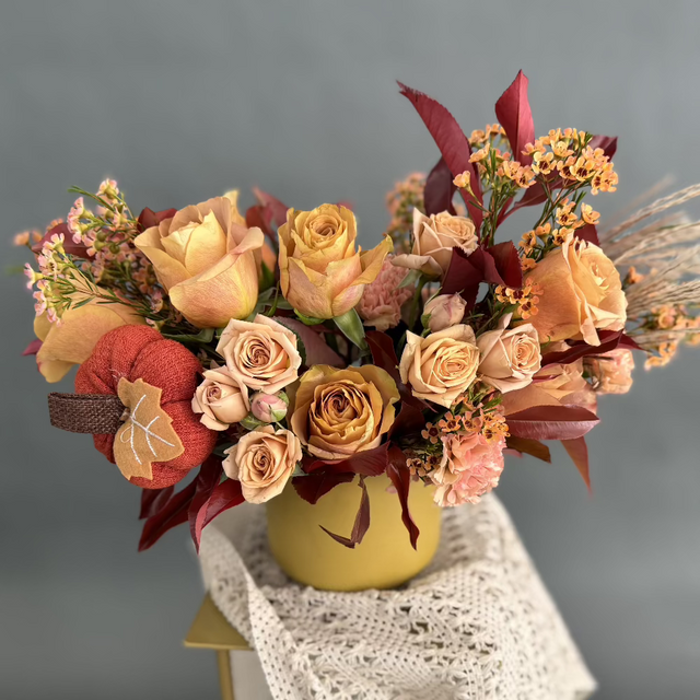 Autumn centerpiece with roses, carnations, wax flowers.