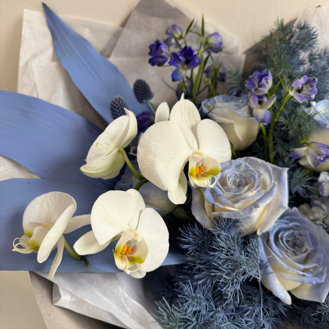 Modern blue floral arrangement with white orchids
