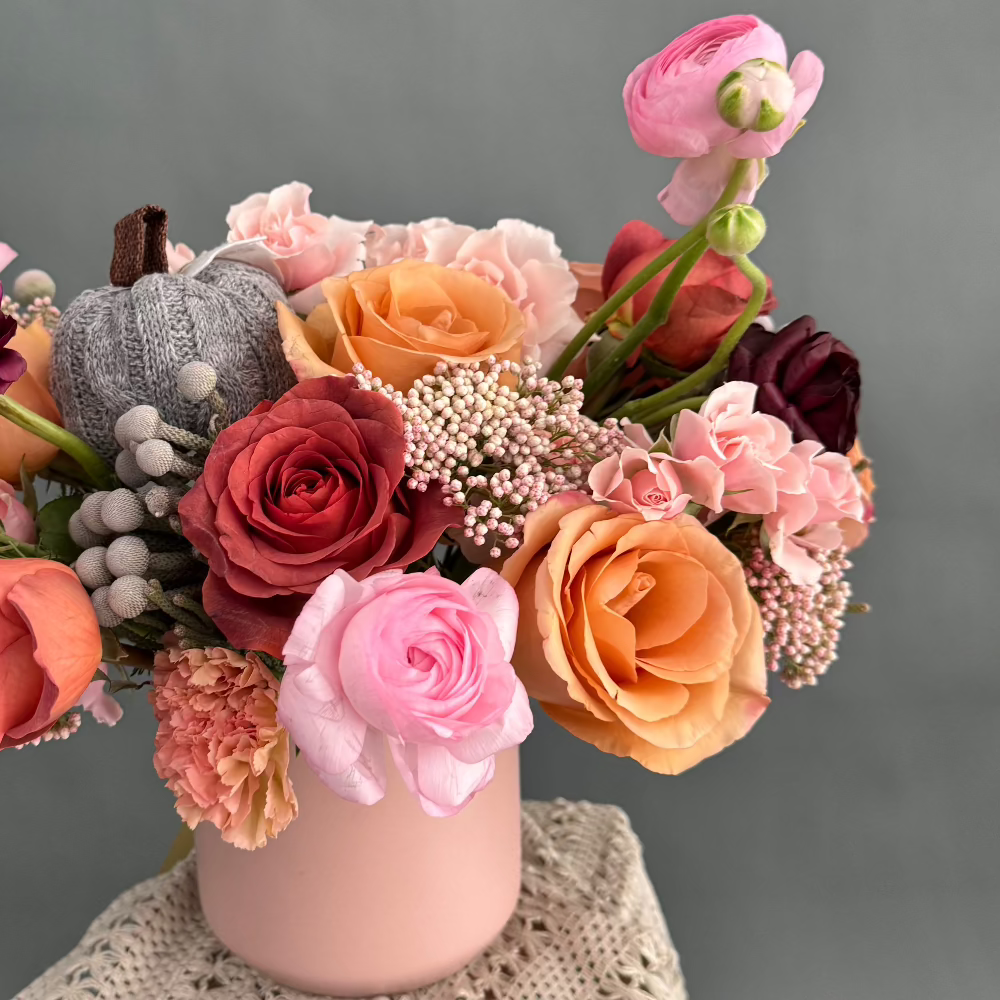 Pink Whisper fresh flowers centerpiece in a pink clay vase.