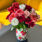 Pink and red Valentine’s flowers styled in a decorative heart-themed vase