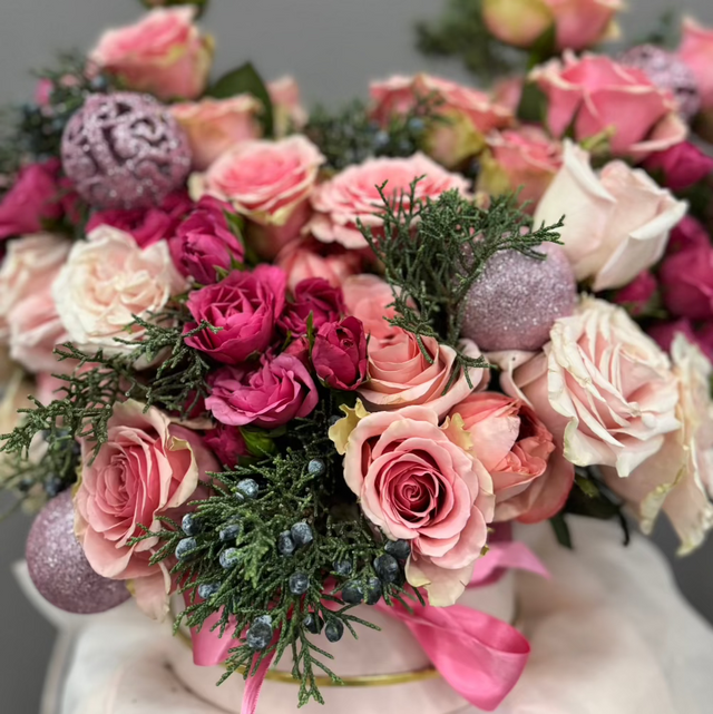 Mix of pink flowers with ornaments in the hat box.