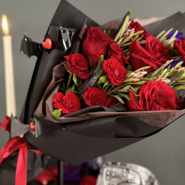 Red Roses with purple Veronica in black paper.