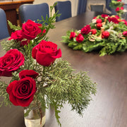 S-shaped evergreen holiday centerpiece made with cedar, juniper, and noble fir