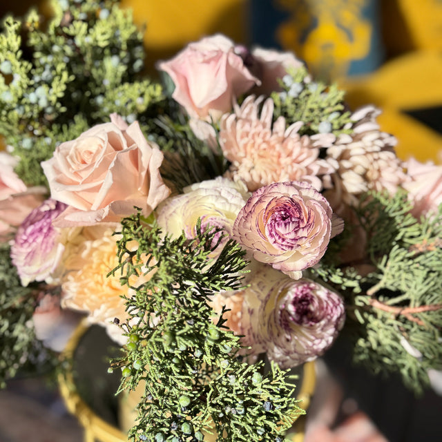 Seasonal holiday flower centerpiece with juniper, carnations, and mums
