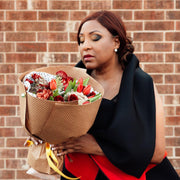 Bouquet of red flowers in the hands of a woman