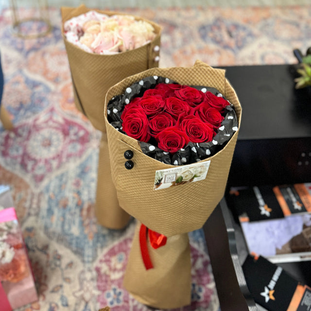 Romantic Valentine’s Day bouquet with red roses and stylish paper wrap
