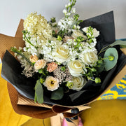 Beautiful bouquet of white flowers in black wrapping.