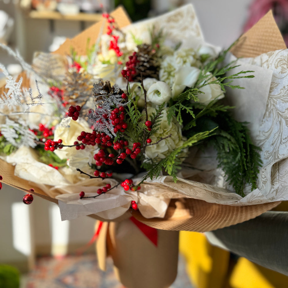 White flowers, red ilex berries and cedar in one fresh flowers bouquet.