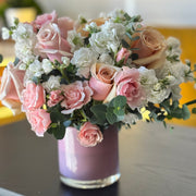 Pink Muse floral arrangement with light pink roses in a soft pink glass vase