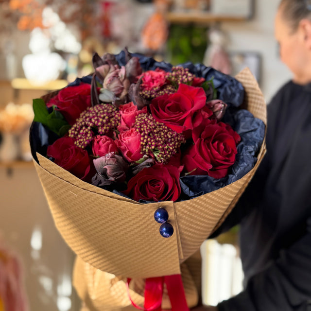Rustic Flame bouquet by Flowers’ Cuddles in Springfield, VA — tulips, roses, yarrow, and ruscus wrapped in navy and kraft for DMV flower delivery