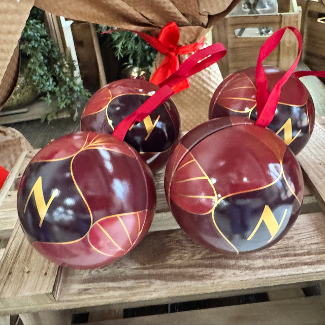 Decorative balls with red ribbons on a wooden surface