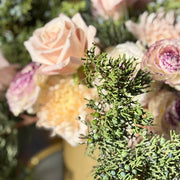 Close-up of a bouquet with pink and purple flowers and greenery.