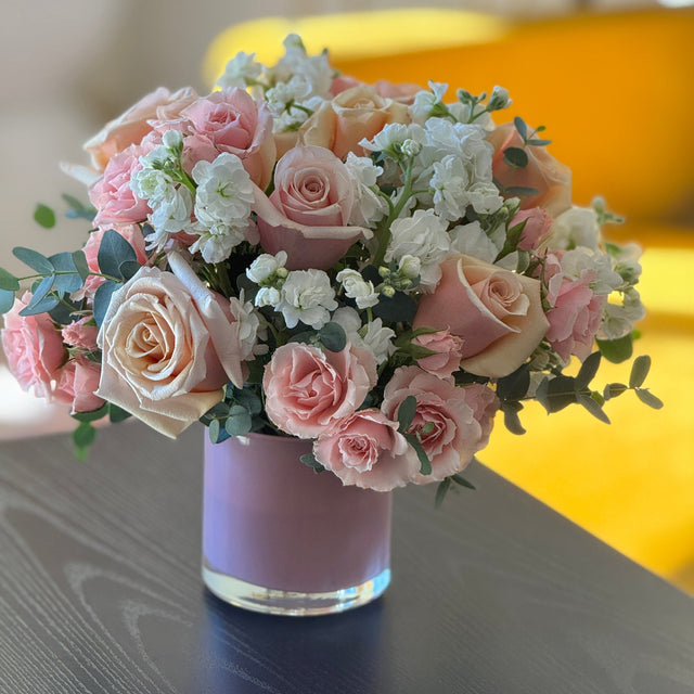 Bouquet of pink and white roses in a pink vase 