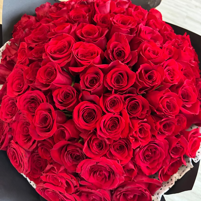 Close-up of premium long-stem red roses wrapped in black paper