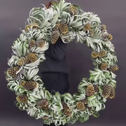 Large 35-inch holiday wreath made from palm leaves and golden pinecones with snowy accents.