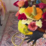 Autumn-inspired floral centerpiece with roses, dahlias, and mums arranged in a pumpkin container