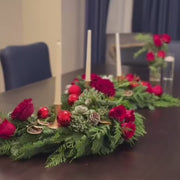S-shaped evergreen centerpiece styled for an elegant holiday dining table