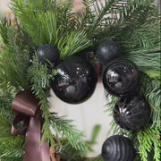 Elegant black-themed holiday wreath featuring evergreens, amaranthus, and satin ribbon.