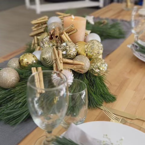 Long S-shaped pine centerpiece with gold and silver ornaments for modern holiday décor