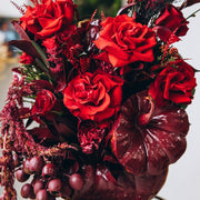 Elegant red pumpkin flower arrangement with rich crimson roses and seasonal autumn accents.