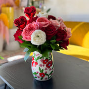 Valentine’s Day flower arrangement with red and pink roses in a patterned ceramic vase