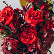 Sophisticated red rose centerpiece in a decorative red pumpkin for an elegant Thanksgiving table.