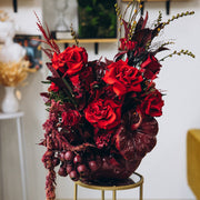 Crimson Obsession luxury fall floral centerpiece featuring red roses in a hand-painted red pumpkin.