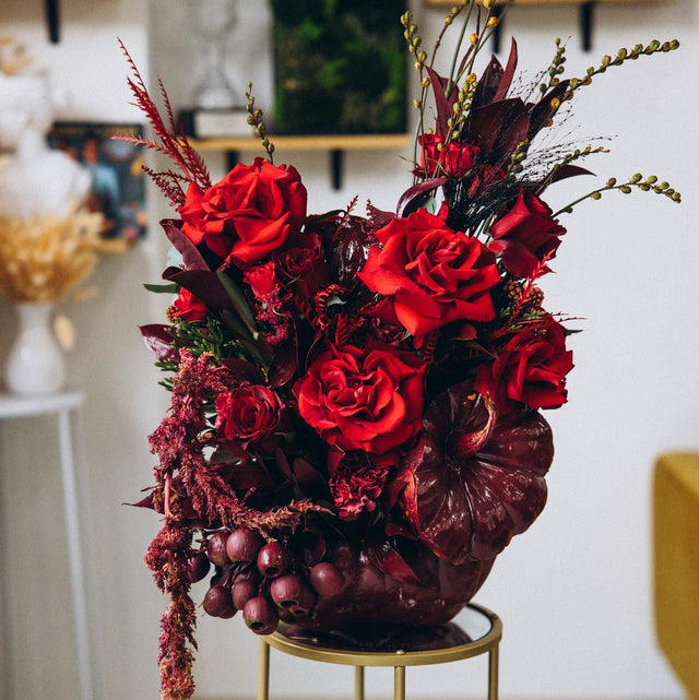 Crimson Obsession luxury fall floral centerpiece featuring red roses in a hand-painted red pumpkin.