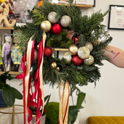 Decorative wreath with ornaments and ribbons in a living room setting